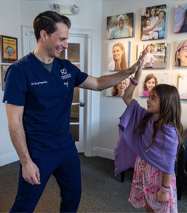 Dr. Papasikos celebrating with a young patient at Papasikos Orthodontics